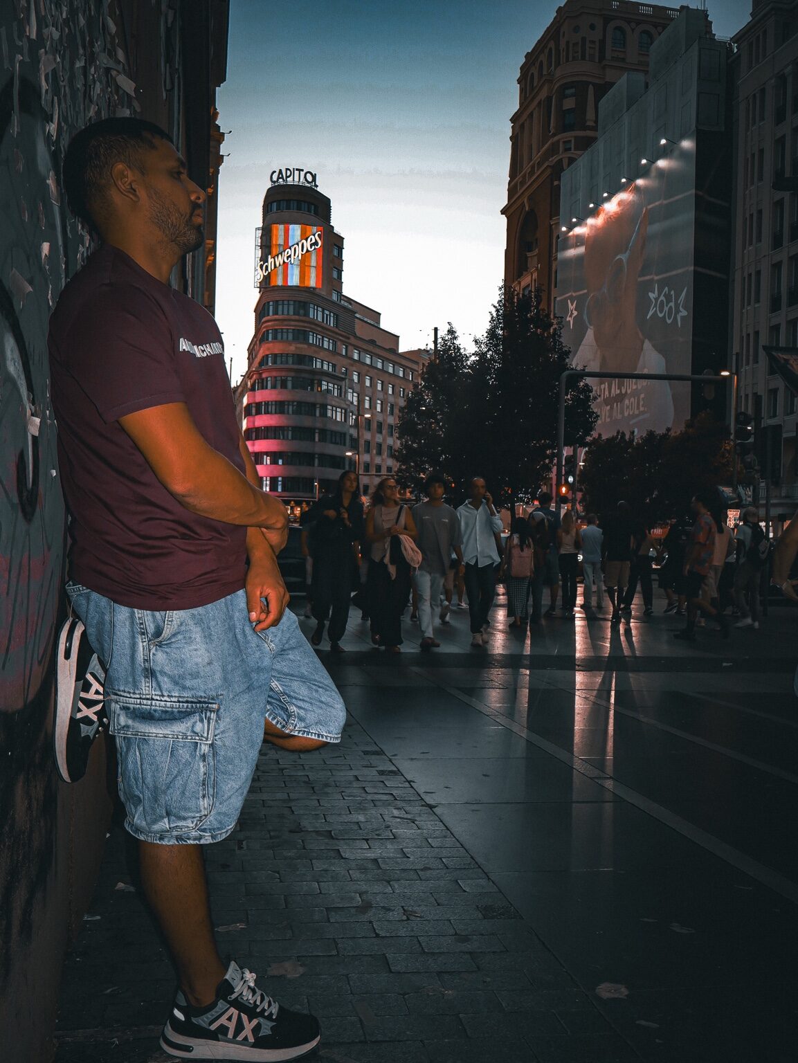 Hombre apoyado en una pared en una calle de Madrid