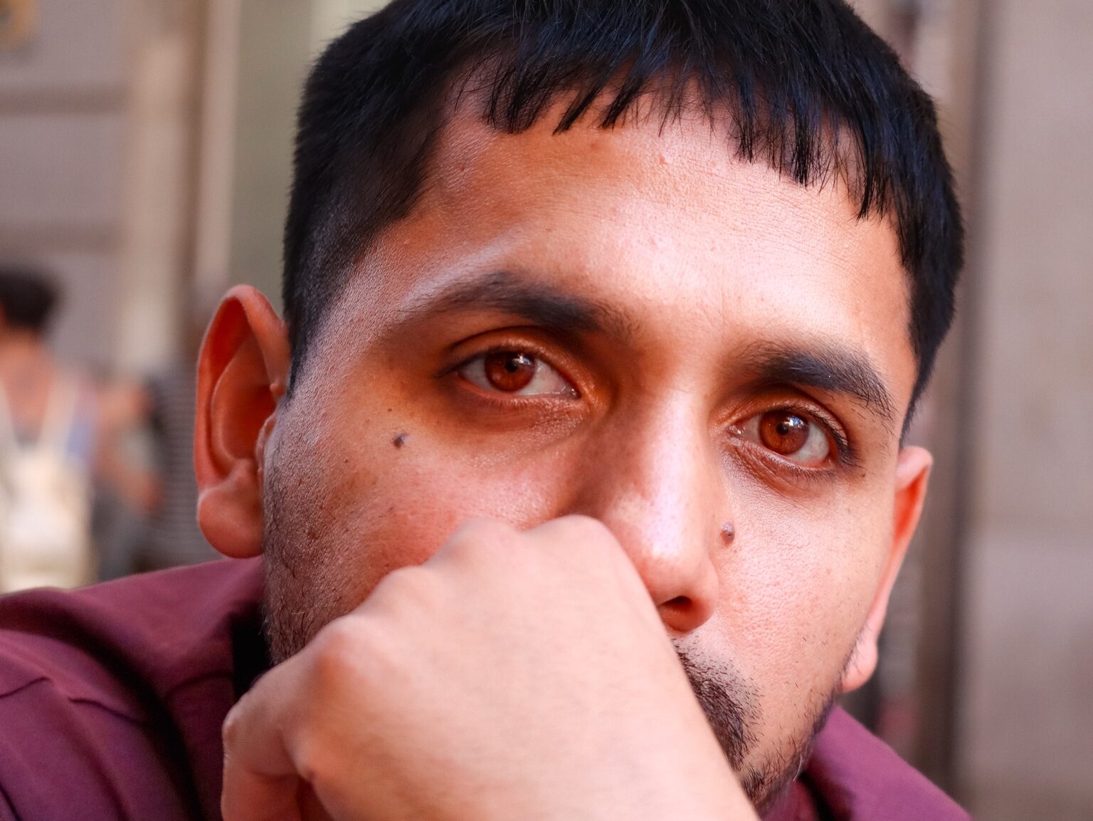 Primer plano de un hombre con la mano junto al rostro